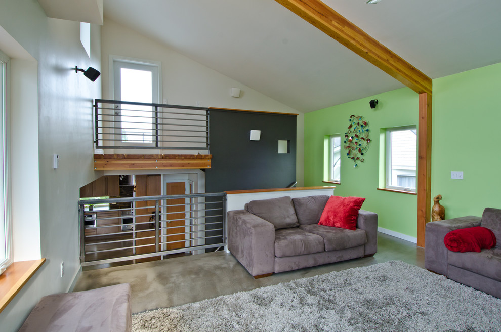 Photo of a large modern open concept living room in Seattle with green walls, medium hardwood floors, no fireplace and a freestanding tv.