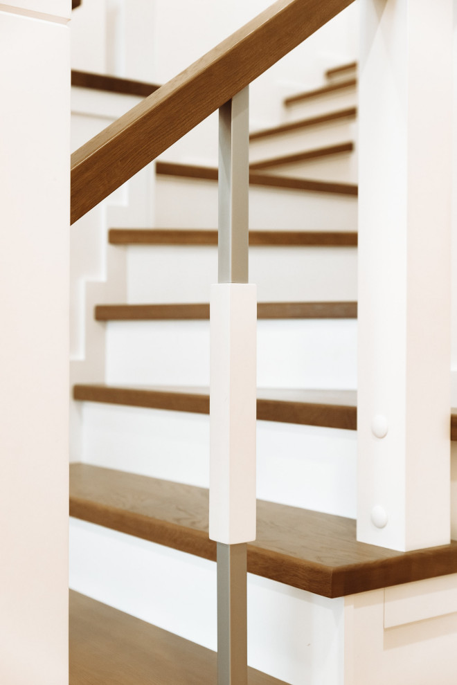 Пример оригинального дизайна: большая изогнутая деревянная лестница в современном стиле с деревянными ступенями, металлическими перилами и кирпичными стенами