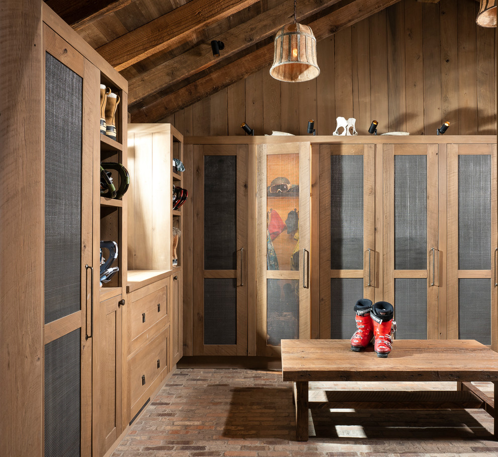 Inspiration for a large country mudroom in Other with brown walls, brick floors and multi-coloured floor.