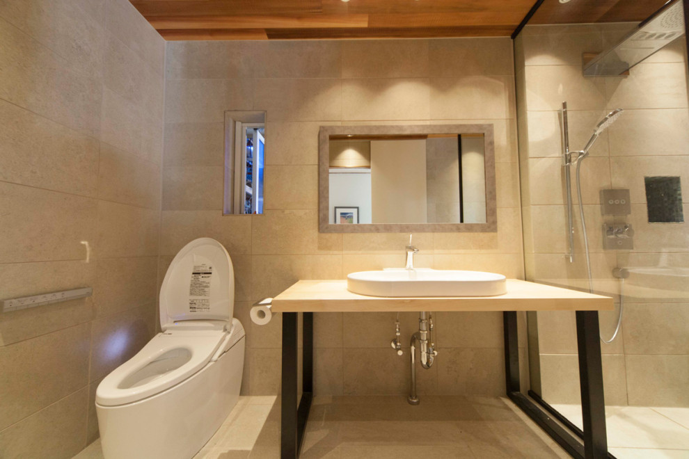 This is an example of a mid-sized transitional powder room in Other with white cabinets, a one-piece toilet, porcelain tile, beige walls, porcelain floors, a vessel sink, beige floor, beige benchtops and a freestanding vanity.