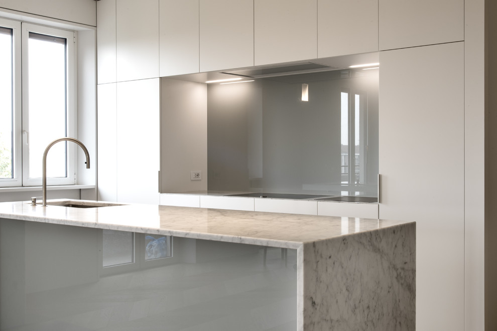 Esempio di un'ampia cucina minimalista con lavello sottopiano, ante lisce, ante bianche, top in marmo, paraspruzzi grigio, paraspruzzi con lastra di vetro e elettrodomestici in acciaio inossidabile