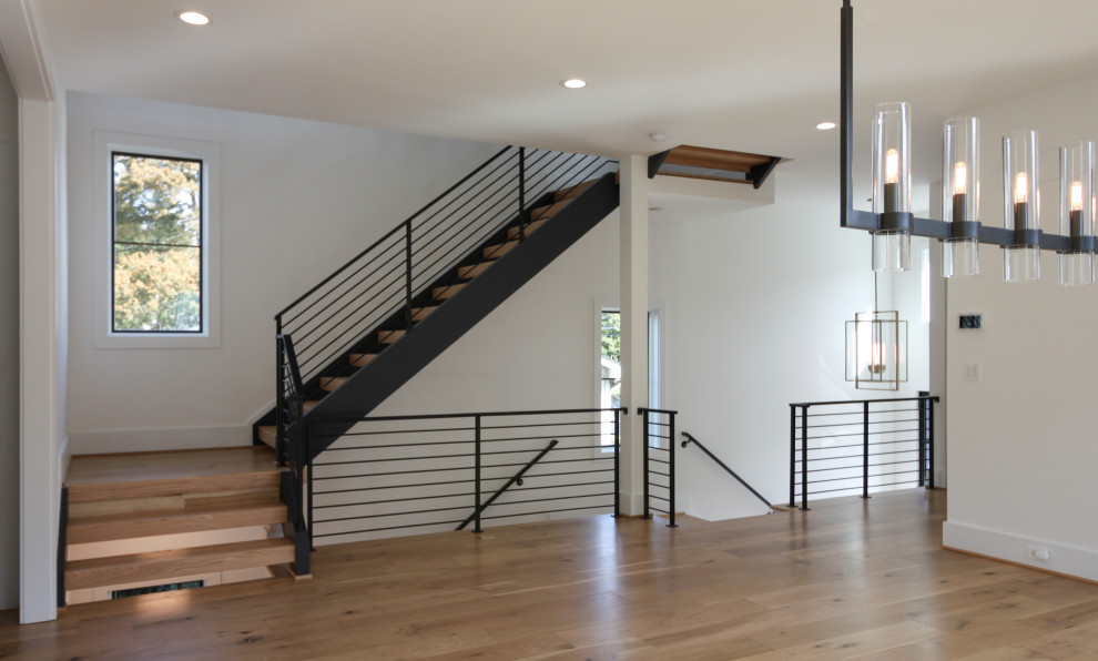 Modelo de escalera recta contemporánea de tamaño medio con escalones de madera y barandilla de metal