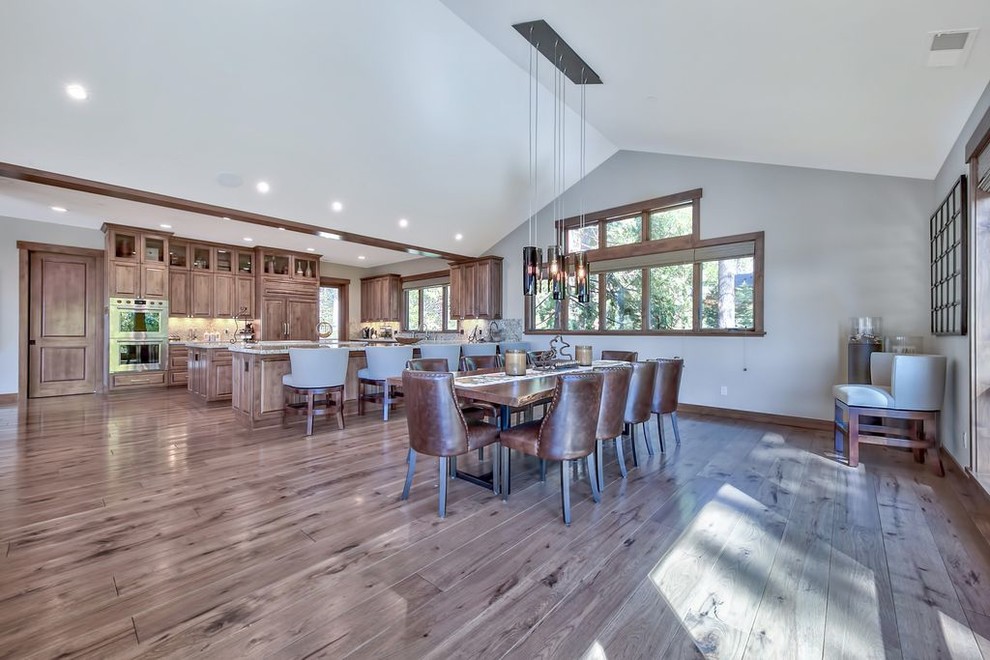 Large transitional medium tone wood floor and multicolored floor kitchen/dining room combo photo with gray walls