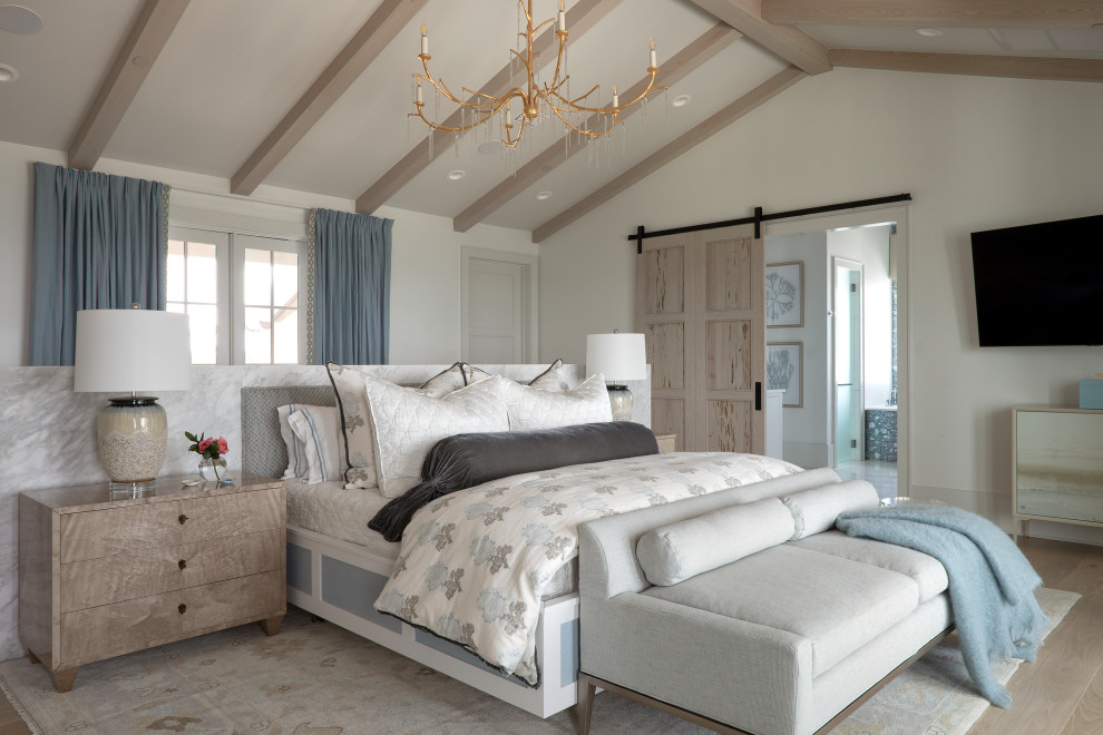Imagen de dormitorio principal y abovedado costero grande con paredes blancas, suelo de madera clara, suelo beige y vigas vistas