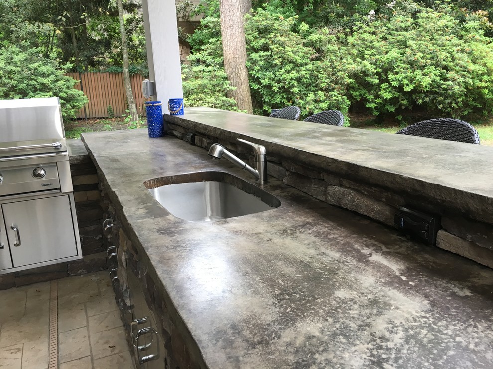Traditional backyard verandah in Houston with an outdoor kitchen, stamped concrete and a roof extension.