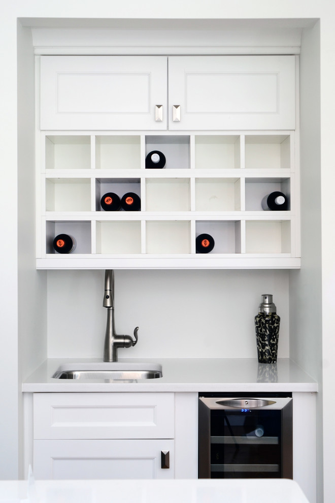 Inspiration for a small traditional single-wall wet bar in Toronto with an undermount sink, recessed-panel cabinets, white cabinets, quartzite benchtops and white splashback.