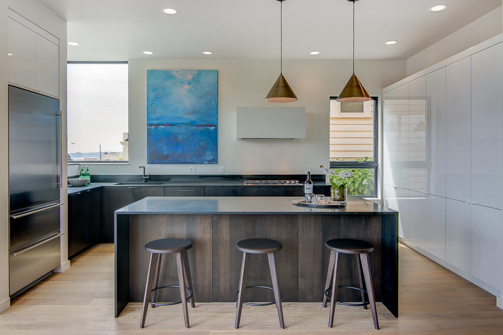 Design ideas for a mid-sized contemporary open plan kitchen in Seattle with an undermount sink, flat-panel cabinets, dark wood cabinets, granite benchtops, stainless steel appliances, light hardwood floors and with island.
