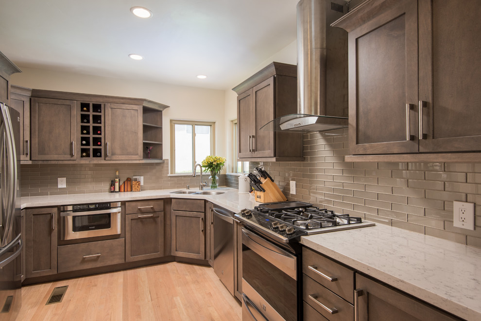 Photo of a mid-sized transitional u-shaped kitchen pantry in San Diego with an undermount sink, shaker cabinets, distressed cabinets, quartz benchtops, grey splashback, subway tile splashback, stainless steel appliances and light hardwood floors.