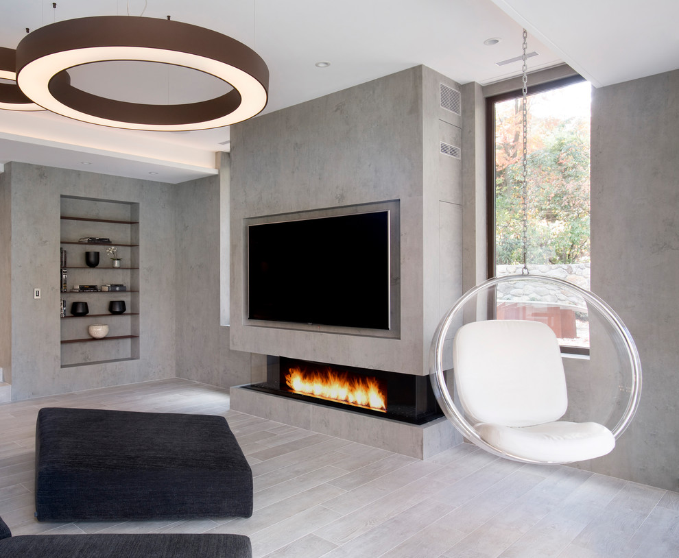 This is an example of a mid-sized modern enclosed family room in Boston with a game room, grey walls, porcelain floors, a ribbon fireplace, a stone fireplace surround, a built-in media wall and grey floor.