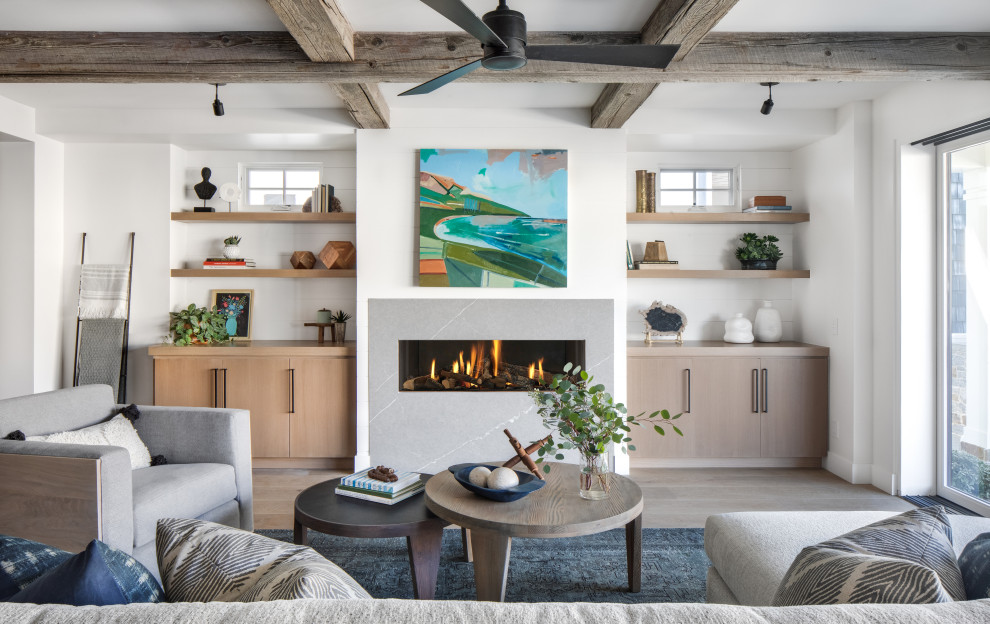 Inspiration for a large beach style open concept family room in Orange County with white walls, light hardwood floors, a ribbon fireplace, a stone fireplace surround, no tv and beige floor.