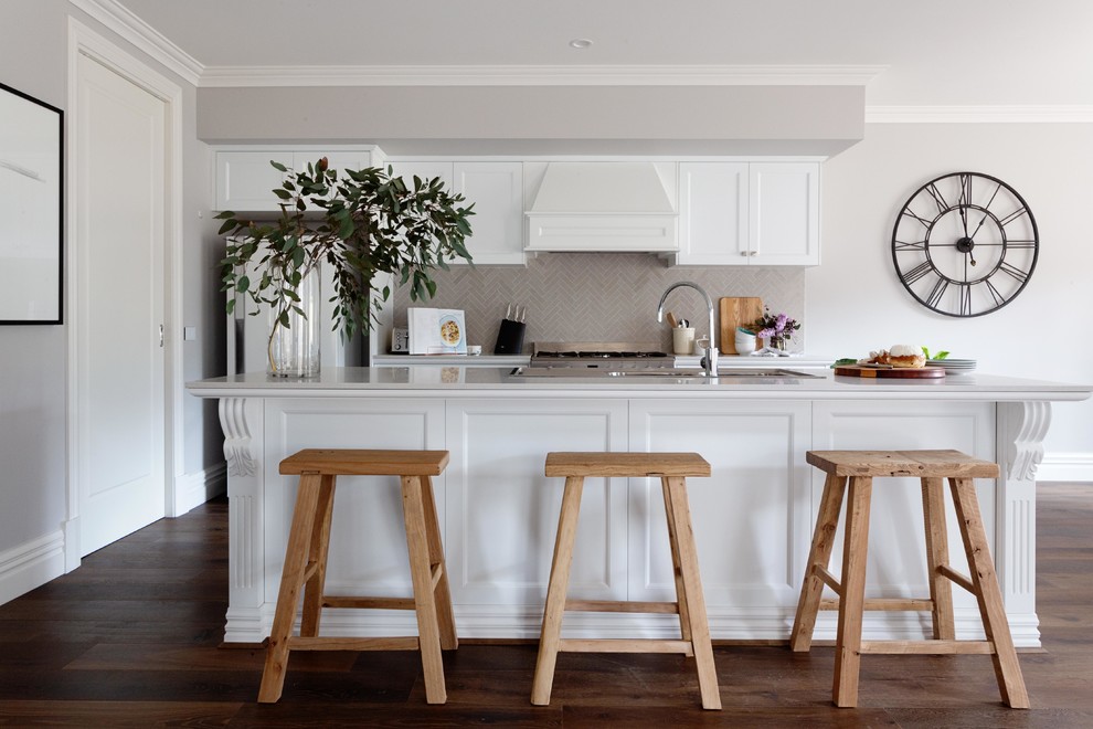 Inspiration for a mid-sized transitional galley open plan kitchen in Melbourne with an undermount sink, shaker cabinets, white cabinets, quartz benchtops, grey splashback, stone tile splashback, stainless steel appliances, dark hardwood floors, with island, brown floor and grey benchtop.