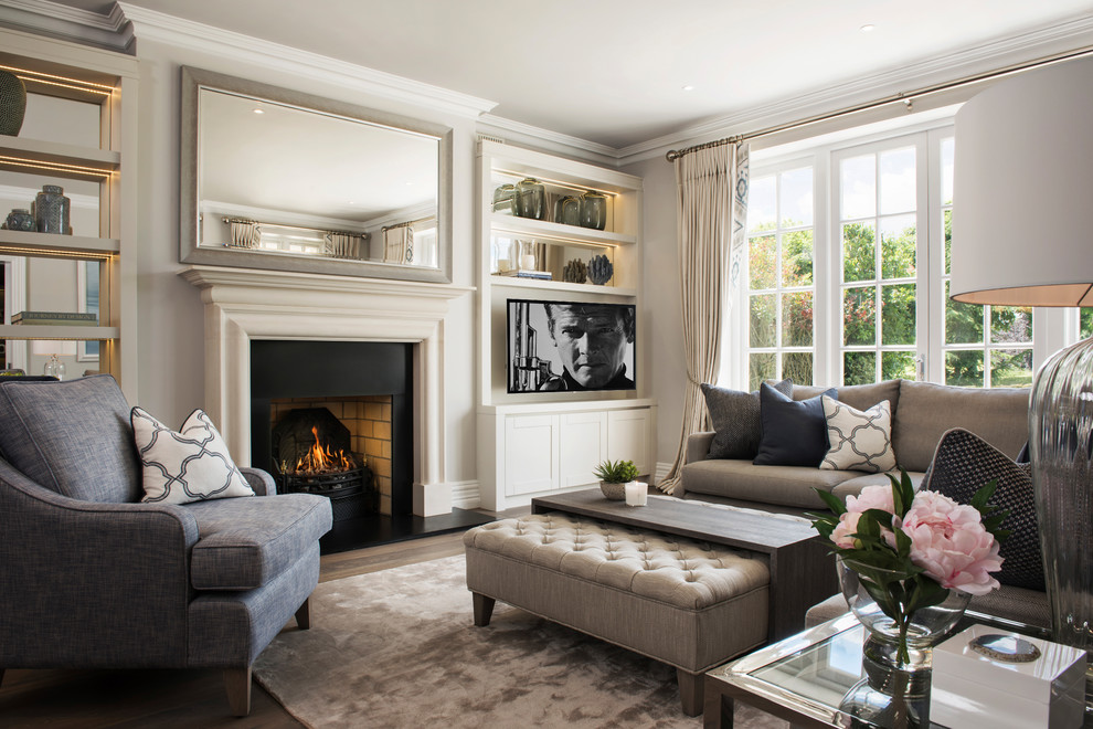 This is an example of a mid-sized transitional living room in Dublin with white walls, a standard fireplace and a wall-mounted tv.