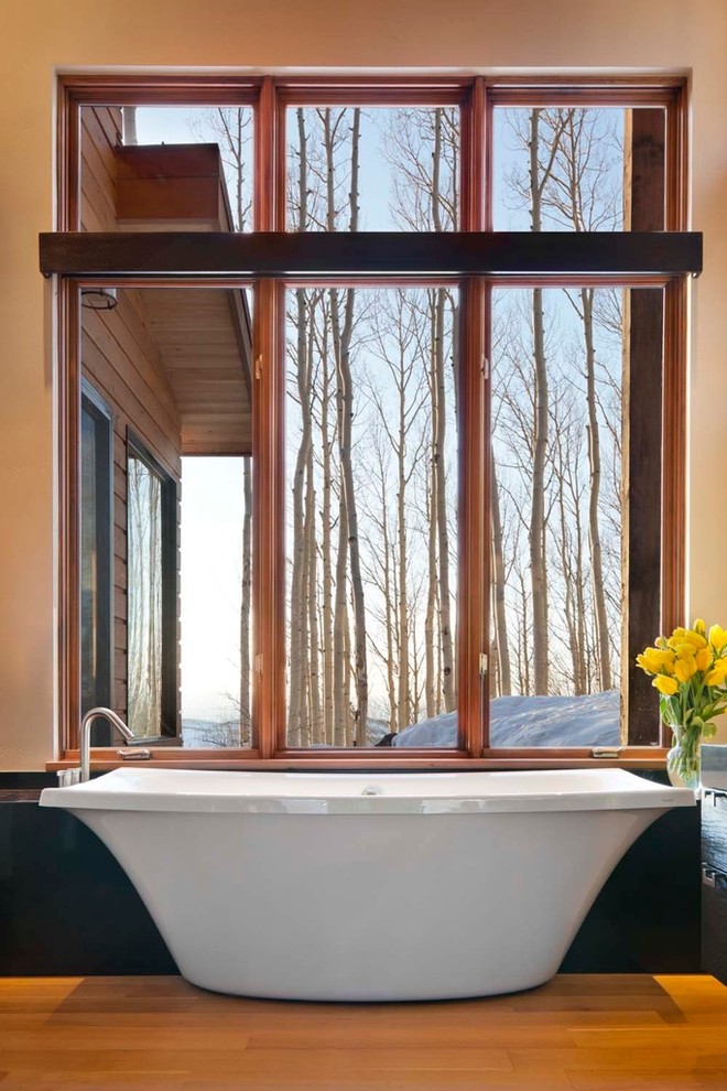 Trendy gray tile and porcelain tile freestanding bathtub photo in Denver with a vessel sink, quartzite countertops and a one-piece toilet