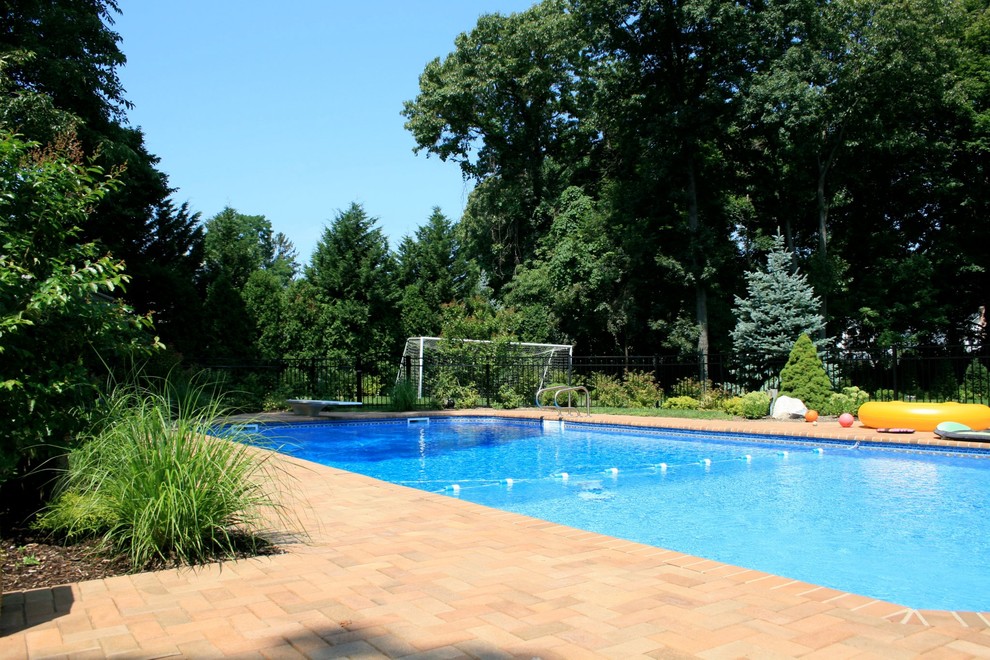 Photo of a large transitional backyard rectangular lap pool in New York with concrete pavers.