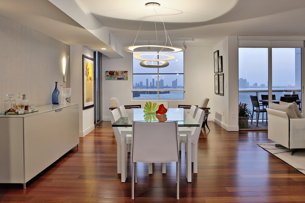 This is an example of a mid-sized contemporary open plan dining in Miami with white walls, medium hardwood floors, no fireplace and beige floor.
