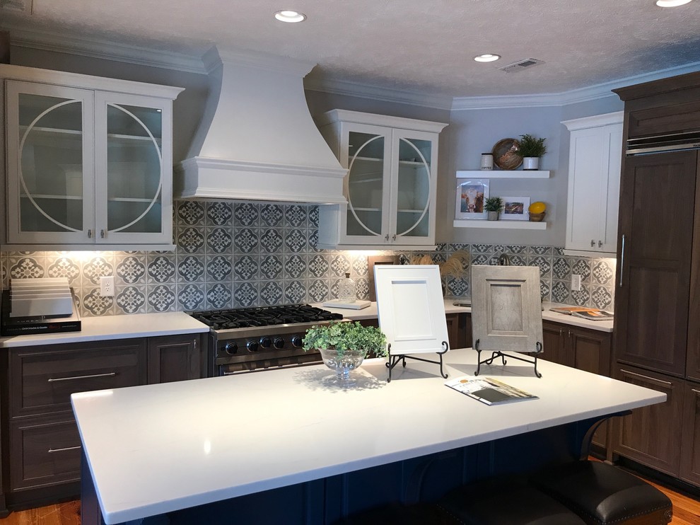 Inspiration for a large country l-shaped eat-in kitchen in Raleigh with an undermount sink, shaker cabinets, quartz benchtops, cement tile splashback, stainless steel appliances, medium hardwood floors, with island and brown floor.