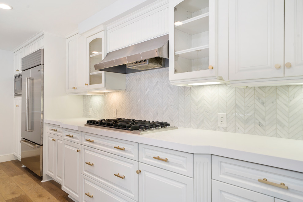 Eat-in kitchen - mid-sized transitional laminate floor and brown floor eat-in kitchen idea in Orange County with an undermount sink, shaker cabinets, blue cabinets, quartz countertops, white backsplash, mosaic tile backsplash, stainless steel appliances, an island and white countertops