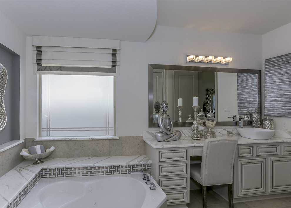 Großes Modernes Badezimmer En Suite mit grauen Schränken, Eckbadewanne, beigen Fliesen, Keramikfliesen, weißer Wandfarbe, Aufsatzwaschbecken, Marmor-Waschbecken/Waschtisch, weißer Waschtischplatte, Einzelwaschbecken, eingebautem Waschtisch und profilierten Schrankfronten in Miami