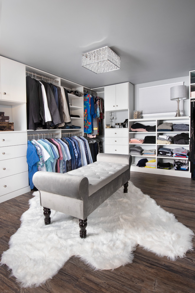 Inspiration for a large transitional gender-neutral walk-in wardrobe in Chicago with flat-panel cabinets, white cabinets, vinyl floors and brown floor.