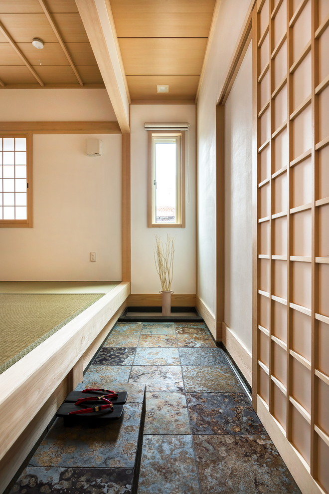 Asian entry hall in Other with white walls, a sliding front door, a light wood front door and grey floor.
