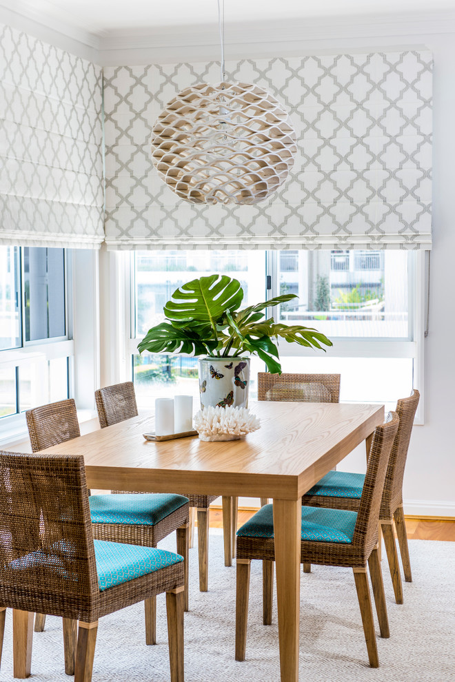 Design ideas for a beach style dining room in Brisbane with white walls and medium hardwood floors.