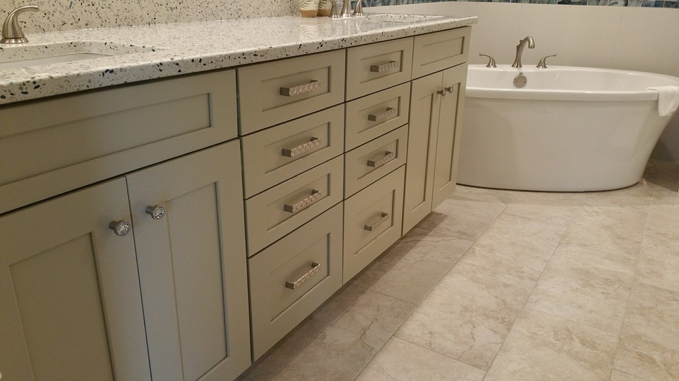 Photo of a mid-sized beach style master bathroom in Tampa with shaker cabinets, beige cabinets, a freestanding tub, a double shower, beige tile, porcelain tile, porcelain floors, an undermount sink, recycled glass benchtops, beige floor, a hinged shower door and multi-coloured benchtops.