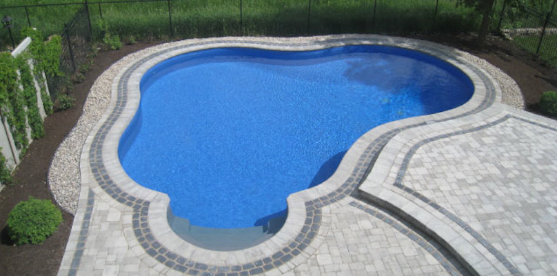 Inspiration for a mid-sized backyard concrete paver and freeform pool remodel