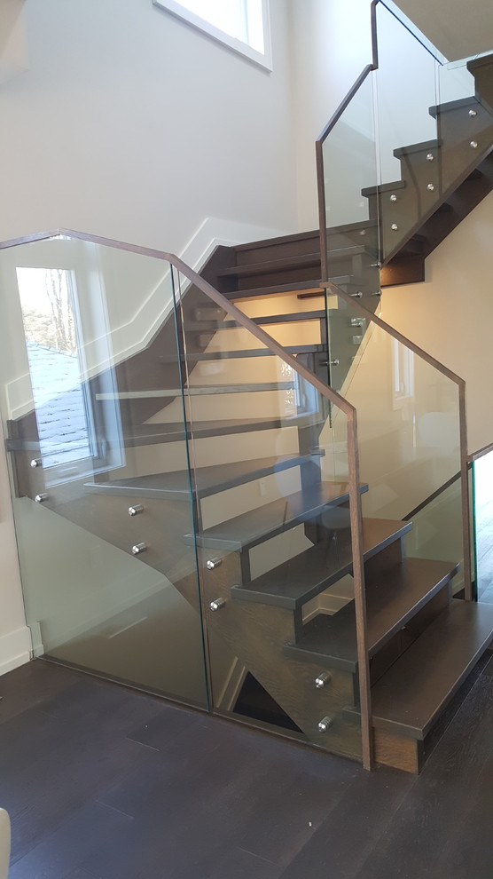 Inspiration for a large modern painted wood u-shaped staircase in Toronto with open risers and glass railing.
