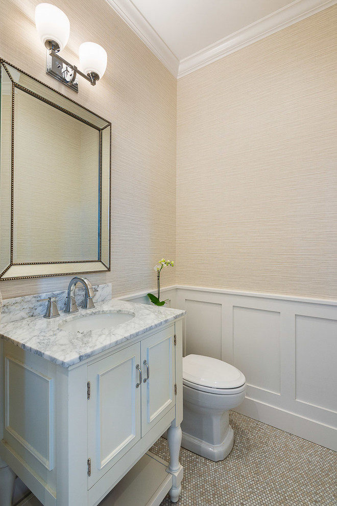 Photo of a small transitional powder room in Other with furniture-like cabinets, white cabinets, a two-piece toilet, beige walls, porcelain floors, an undermount sink, marble benchtops, beige floor and grey benchtops.