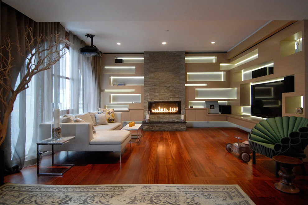 Photo of a mid-sized contemporary open concept living room in New York with a library, a ribbon fireplace, a stone fireplace surround, a built-in media wall and medium hardwood floors.