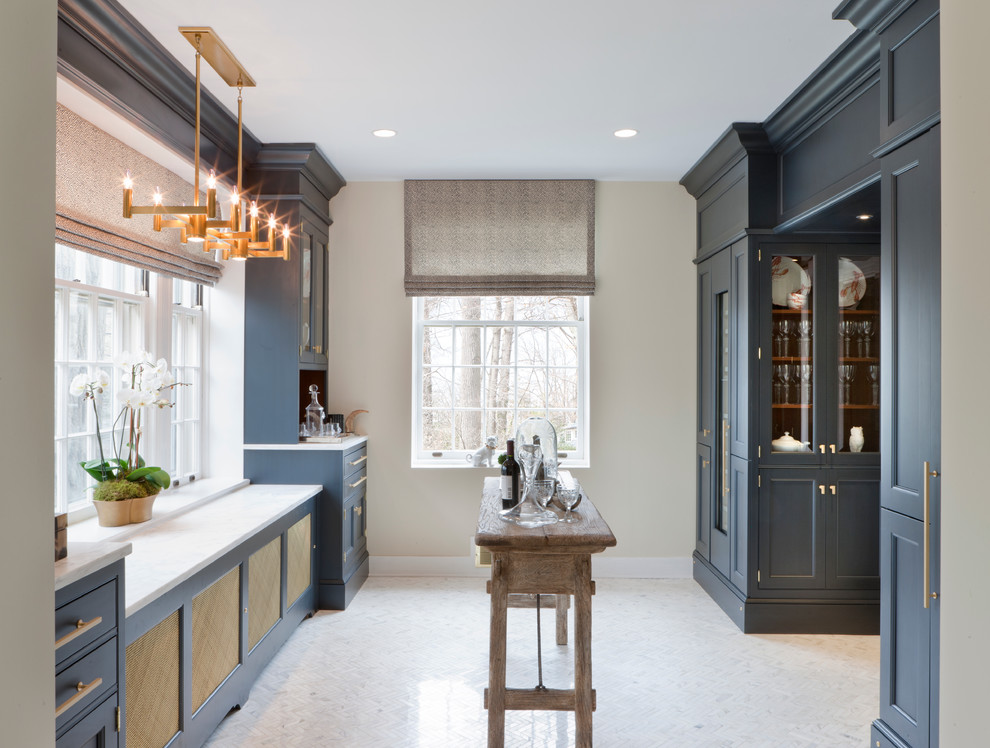 Photo of a small traditional galley kitchen in DC Metro with blue cabinets, marble benchtops, panelled appliances and marble floors.