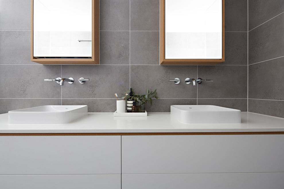 Photo of a mid-sized modern master bathroom in Melbourne with white cabinets, an open shower, gray tile, grey walls, a vessel sink, grey floor, an open shower, white benchtops, furniture-like cabinets and engineered quartz benchtops.
