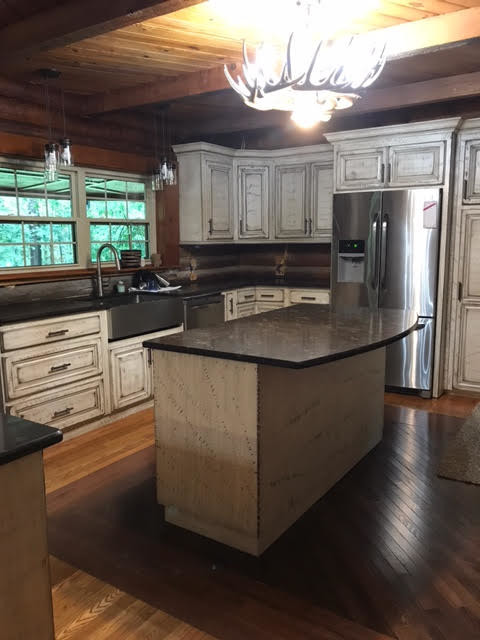Inspiration for a large rustic u-shaped medium tone wood floor and brown floor eat-in kitchen remodel in Birmingham with a farmhouse sink, raised-panel cabinets, distressed cabinets, stainless steel appliances and an island