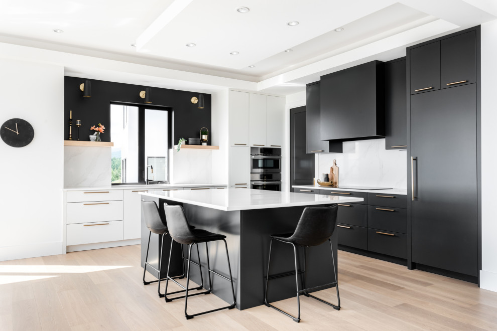 Inspiration for a contemporary kitchen in Vancouver with an undermount sink, flat-panel cabinets, black cabinets, quartz benchtops, white splashback, engineered quartz splashback, panelled appliances, light hardwood floors, with island and white benchtop.