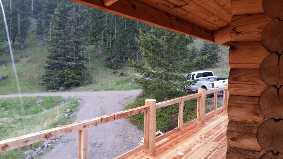 Mid-sized mountain style back porch idea with decking and a roof extension