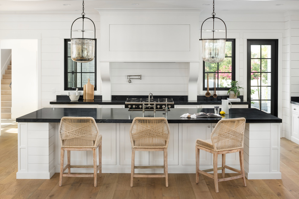 Inspiration for a large country single-wall kitchen in Phoenix with shaker cabinets, white cabinets, soapstone benchtops, light hardwood floors, with island and black benchtop.