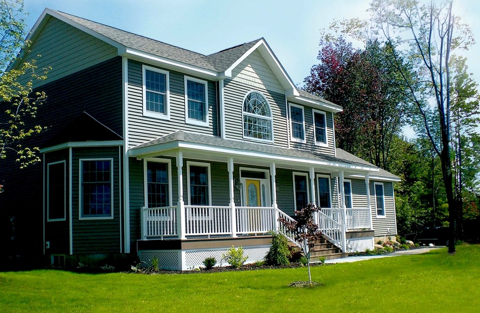 This is an example of a large beach style two-storey green exterior in New York with vinyl siding and a gable roof.