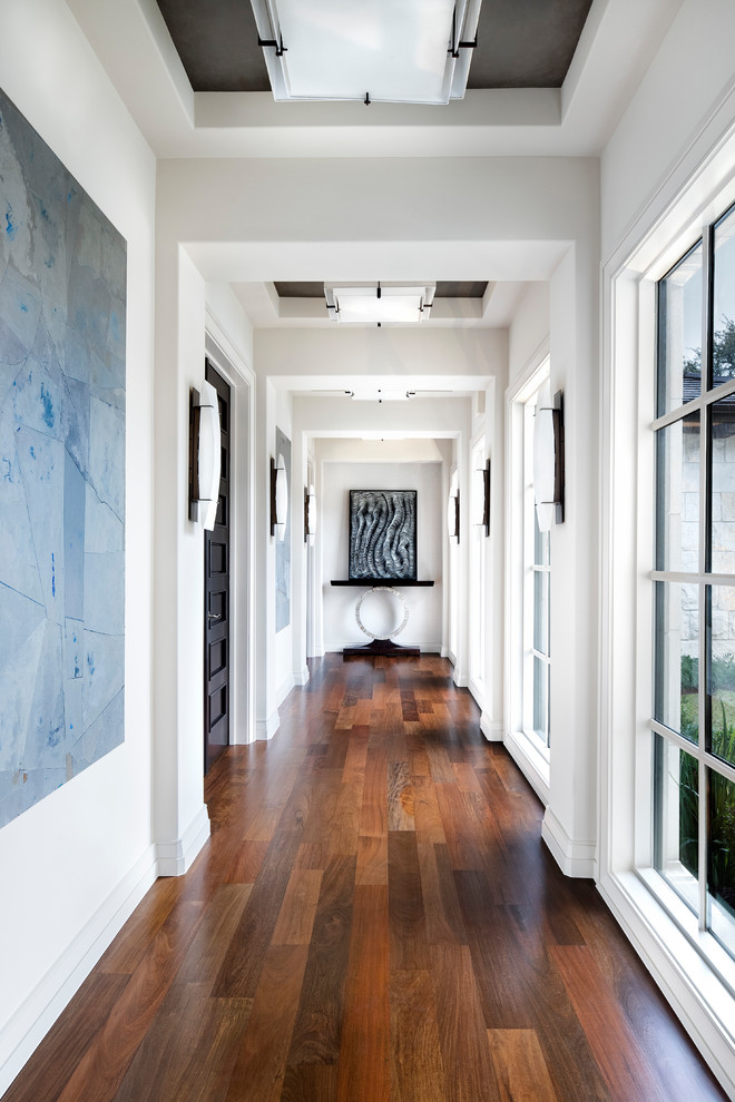 Design ideas for an expansive transitional hallway in Austin with white walls, medium hardwood floors and brown floor.