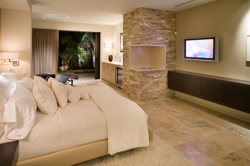 Inspiration for a contemporary master bedroom in Orlando with beige walls, a corner fireplace, a stone fireplace surround and travertine floors.