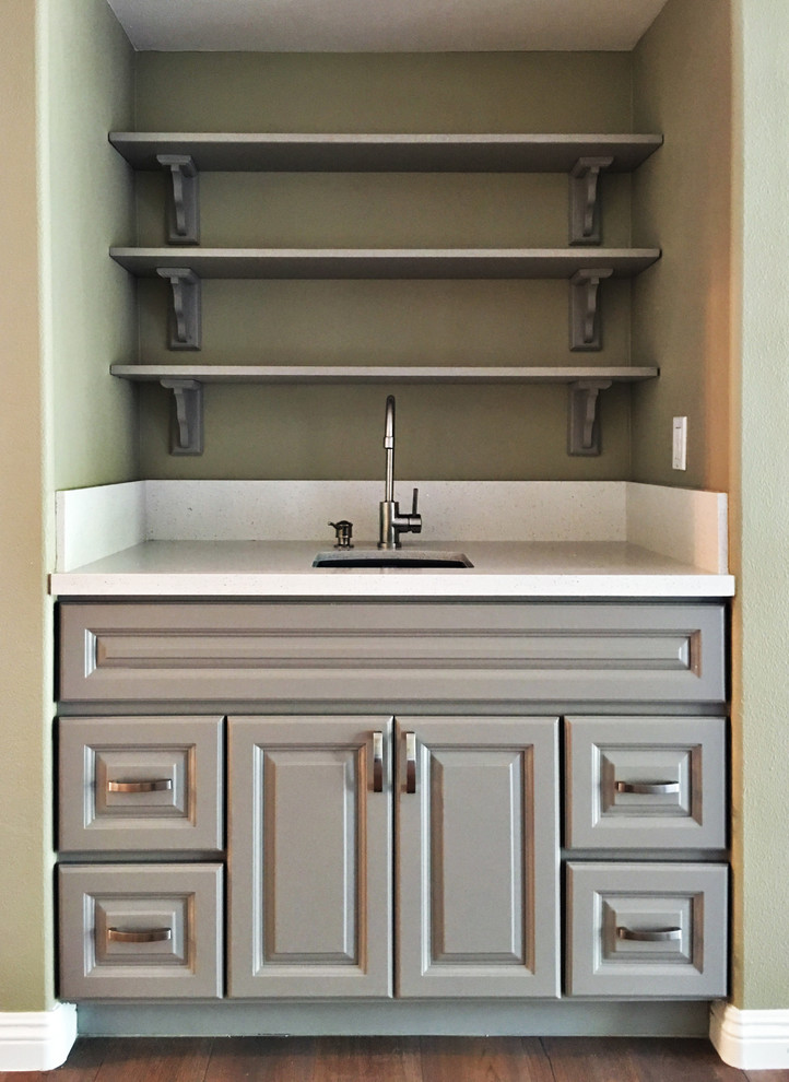 Eat-in kitchen - mid-sized transitional u-shaped medium tone wood floor eat-in kitchen idea in Orange County with raised-panel cabinets, gray cabinets, quartz countertops, a peninsula, a single-bowl sink, white backsplash, stone slab backsplash and stainless steel appliances