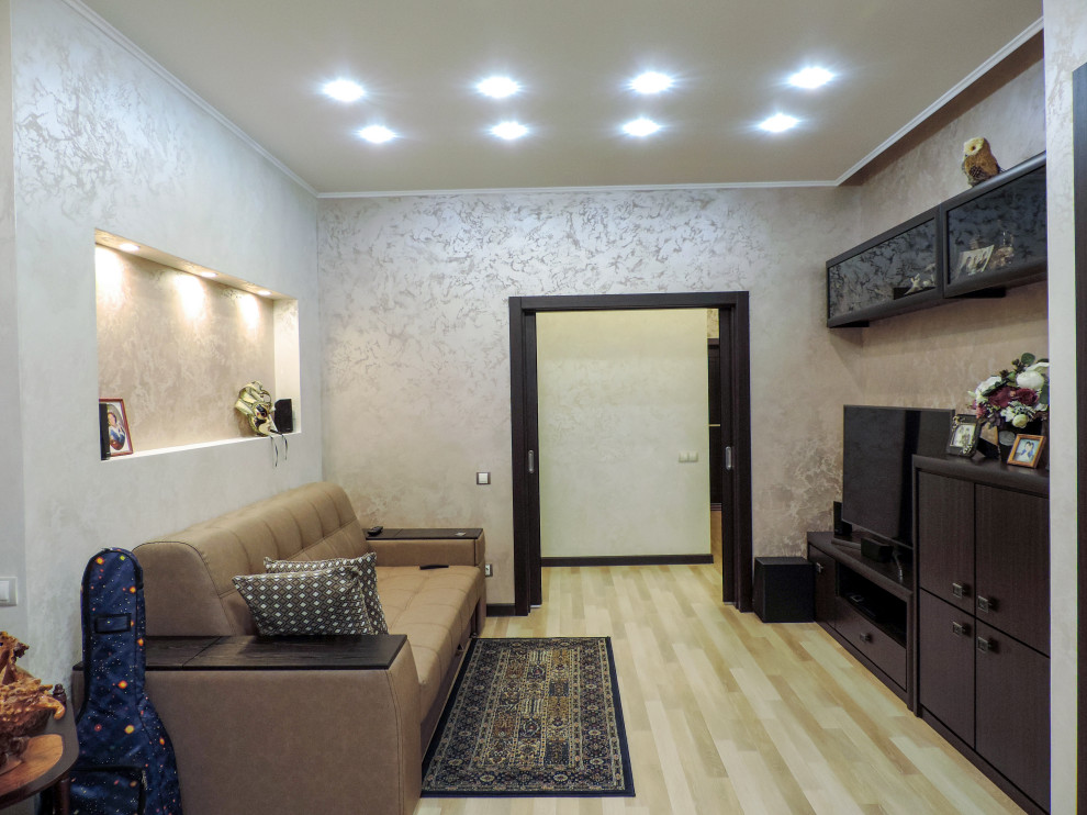 На фото: гостиная комната среднего размера в стиле неоклассика (современная классика) с бежевыми стенами, полом из ламината, отдельно стоящим телевизором, зоной отдыха, бежевым полом и многоуровневым потолком без камина с