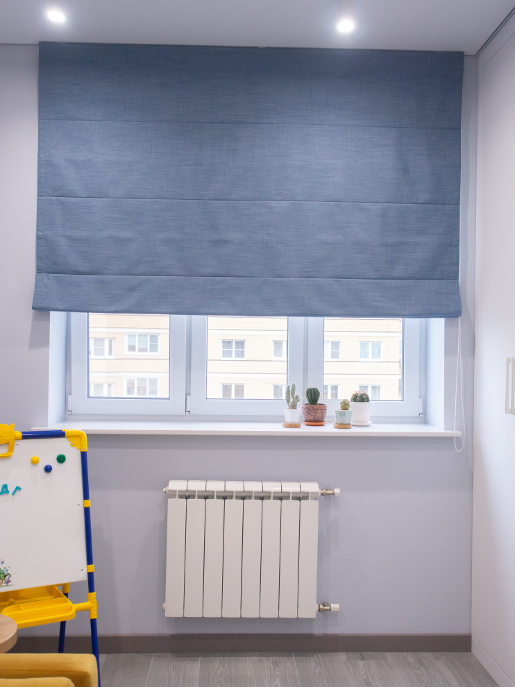 Foto på ett mellanstort funkis könsneutralt barnrum kombinerat med skrivbord, med blå väggar, klinkergolv i porslin och grått golv