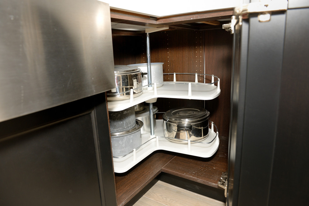 Enclosed kitchen - large transitional u-shaped porcelain tile enclosed kitchen idea in Toronto with a farmhouse sink, beaded inset cabinets, black cabinets, quartzite countertops, white backsplash, ceramic backsplash, stainless steel appliances and no island