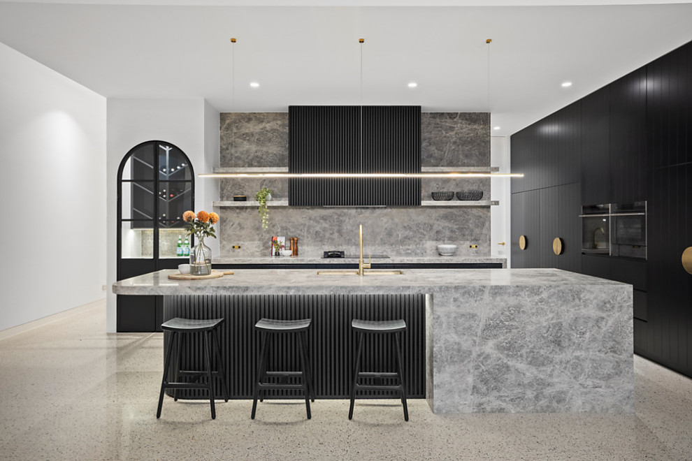 Immagine di una grande cucina design con lavello a doppia vasca, ante nere, top in marmo, paraspruzzi grigio, paraspruzzi in marmo, elettrodomestici neri, pavimento in cemento, pavimento grigio e top grigio