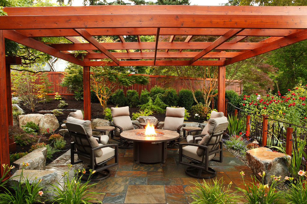 Photo of a traditional backyard patio in Seattle with a fire feature and natural stone pavers.