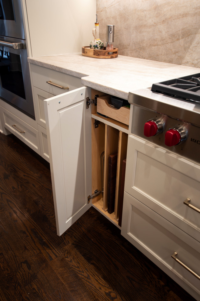 Example of a large transitional l-shaped dark wood floor and brown floor open concept kitchen design in Nashville with an undermount sink, beaded inset cabinets, white cabinets, quartzite countertops, beige backsplash, stone slab backsplash, stainless steel appliances, an island and beige countertops
