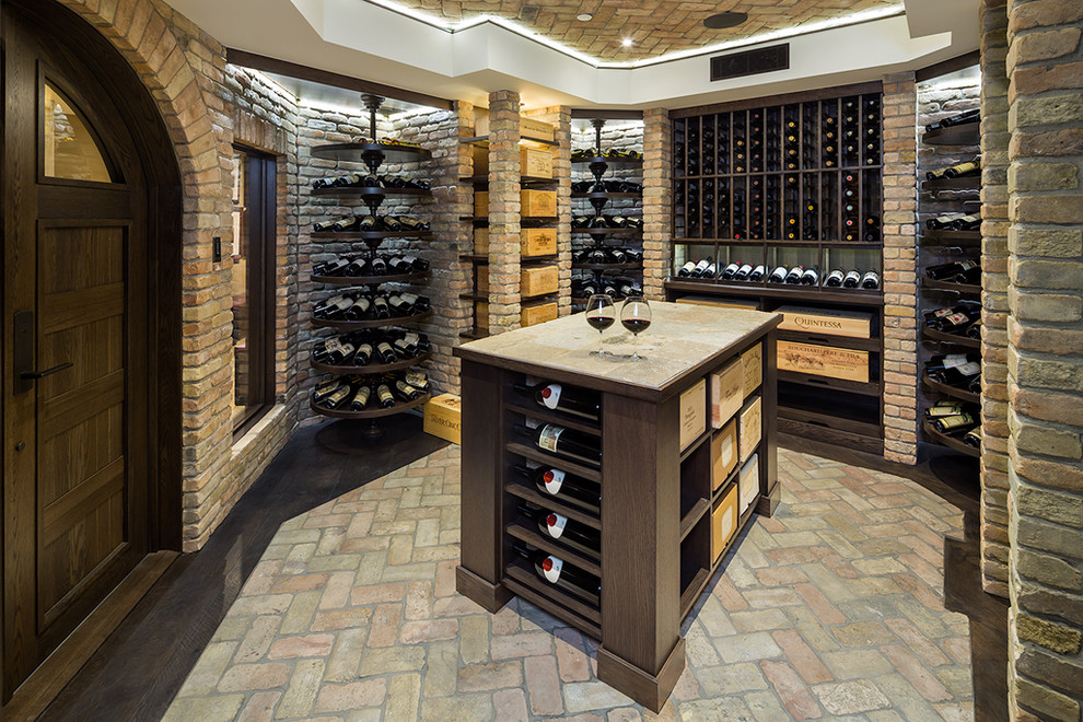 This is an example of an expansive country wine cellar in Other with brick floors, display racks and multi-coloured floor.
