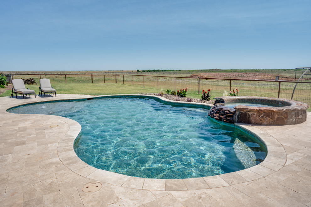 Mid-sized mountain style backyard stone and custom-shaped hot tub photo in Austin