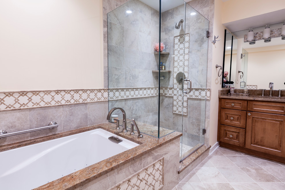 This is an example of a mid-sized traditional master bathroom in Bridgeport with an undermount sink, raised-panel cabinets, medium wood cabinets, granite benchtops, an undermount tub, a shower/bathtub combo, a two-piece toilet, beige tile, porcelain tile, beige walls and porcelain floors.