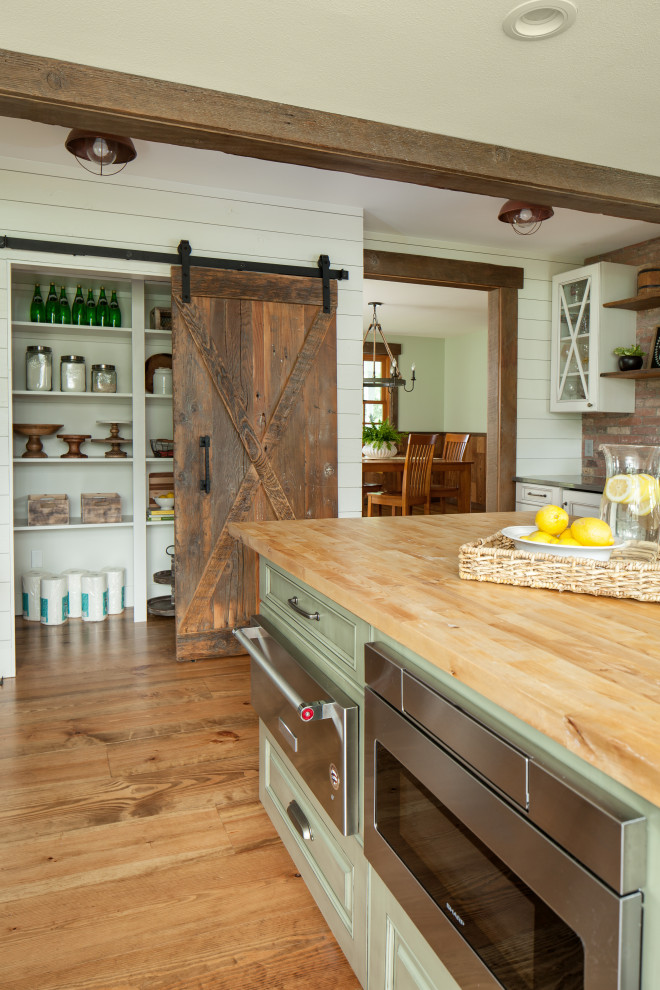 Medium sized farmhouse u-shaped open plan kitchen in Seattle with a submerged sink, raised-panel cabinets, white cabinets, engineered stone countertops, white splashback, tonge and groove splashback, stainless steel appliances, medium hardwood flooring, an island, brown floors and grey worktops.